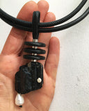 Black unique tourmaline pendant with white pearls on a white background 