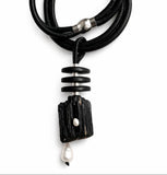 Black leather necklace with a unique tourmaline pendant with white pearls on a white background 
