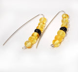 Pair of earrings with yellow and black natural Amber beads on a white background