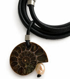 Necklace with a fossil pendant and pearl on a white background
