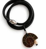 Short statement necklace with a ammonite fossil and pink pearl pendant on a white background